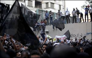 Egyptian protesters climb the walls of the U.S. embassy while others chant anti U.S. slogans during a protest in Cairo, Egypt, Tuesday.