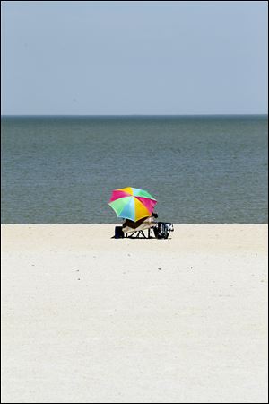 Linda Ritchie from Holland reads on the beach on the final days of summer at Maumee Bay Park on Wednesday.  Ritchie said she enjoys the quiet solitude at the beach this time of year.