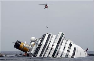 An Italian firefighter is lowered from a helicopter onto the grounded cruise ship Costa Concordia off the Tuscan island of Giglio, Italy.