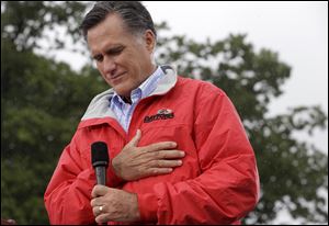 Republican presidential candidate, former Massachusetts Gov. Mitt Romney puts his hand on his heart during a moment of silence today for the embassy officials killed in Libya, as he campaigns in the rain at Lake Erie College in Painesville, Ohio.