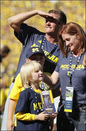 Cooper Barton, 5, front, attends the game with his parents, Chris and Shannon, and brother Nathan.