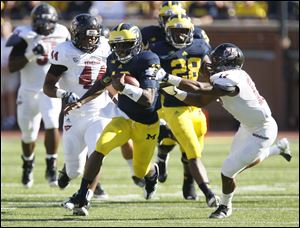 Michigan's Denard Robinson streaks past Randall Jette and the rest of the University of Massachusetts defense. Robinson racked up 397 yards for the Wolverines.