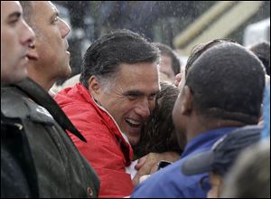Republican presidential candidate Mitt Romney hugs a supporter as he campaigns in the rain.