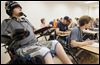  Kyle Cannon,18, listens in class while his health aid, Dan Dorner, center in baseball cap, takes notes for him at Bowling Green State University. Canon was a Clay freshman when he was paralyzed during a hockey game in 2008.