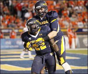 Toledo running back David Fluellen, 22, celebrates with teammate Zac Rosenbauer after scoring a touchdown during the second quarter. He added a second score in the second half to secure the victory.