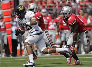 California's Keenan Allen, left, runs after a catch as Ohio State's Travis Howard, center, and Curtis Grant chase him during the first quarter of an NCAA college football game.