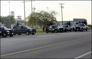 A group of Mexican federal police stand in front of the prison in Piedras Negras, Mexico Monday. Authorities say 132 inmates have escaped from this jail in northern Mexico, sparking a search by federal police and soldiers in an area close to the U.S. border. 