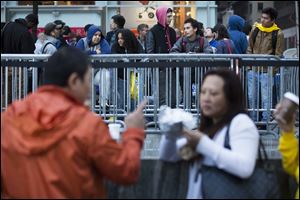 Consumers wait in line outside the Fifth Avenue Apple store for the imminent release of the iPhone 5, on Friday, in New York. Hundreds of people waited in line through the early morning to be among the first to get their hands on the highly anticipated phone.