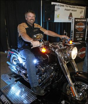Jerry Borstelman, of Harley-Davidson Sales & Service in Toledo, rides a stationary Harley during the Celebrity Boxing event.