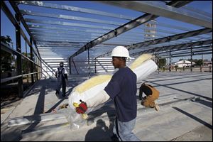 Marco Harris carries a roll of insulation as construction continues on a new Family Dollar store at 1121 W. Bancroft St. The 8,000-square-foot store is expected to be open by Jan. 1, and it will employ eight to 10 workers, a spokesman for the chain said. Family Dollar, based in Matthews N.C., purchased the 0.5-acre site at the end of June for $320,000. The Bancroft store will be Family Dollar's 20th location in Metro Toledo. The retailers, which specializes in discount goods but also carries food items, is opening between 450 and 500 stores in 2012.