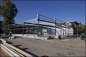 Workers erect the frame of a new Family Dollar store at 1121 Bancroft St. near Monroe Street in Toledo. 