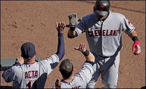 Cleveland Indians' Carlos Santana, right, celebrates as he comes into the dugout after hitting a two-run home run during the sixth inning of a baseball game against the Kansas City Royals.