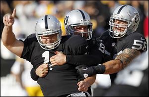Oakland Raiders kicker Sebastian Janikowski  (11) celebrates with holder Shane Lechler (9) and  Dave Tollefson (58) after Janikowski's 43-yard field goal to win the game against the Pittsburgh Steelers during the fourth quarter of an NFL football game in Oakland, Calif. on Sunday.
