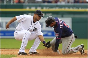 Minnesota Twins' Eduardo Escobar safely steals second under the tag of Detroit Tigers shortstop Jhonny Peralta during the fifth inning of a baseball game at Comerica Park in Detroit.