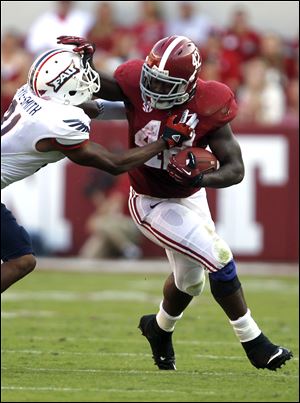 Alabama running back Eddie Lacy (42) stiff-arms Florida Atlantic defensive back D'Joun Smith (21) and runs for a first down during the first half of a NCAA college football game on Saturday.