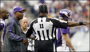 Minnesota Vikings head coach Leslie Frazier, left, talks with side judge Dwayne Strozier, right, during the second half of an NFL football game against the San Francisco 49ers Sunday in Minneapolis.