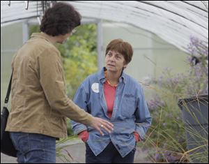 Shopper Melanie Navarre, of Sylvania Township, left, speaks with Toledo Botanical Garden volunteer and native plant expert Denise Gehring at the second day of the garden's annual fall plant sale.
