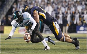 University of Toledo player Dan Molls, 32, hits Coastal Carolina player Tyrell Blanks, 16, causing an incomplete pass during the first quarter at the Glass Bowl, Saturday, September 22, 2012.