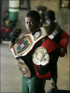 Toledoan Otha Jones III, 12, poses with three of his 10 national boxing tournament belts.