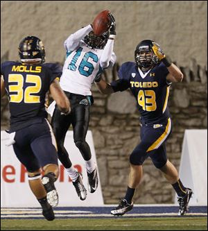 Dan Molls, 32, and Mark Singer, 43, can't keep Coastal Carolina's Tyrell Blanks from hauling in a pass to score a touchdown. The Rockets gave up 356 passing yards to the Chanticleers. 