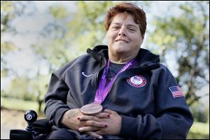 Zena Cole of Oregon relaxes at Pearson Metropark with the bronze medal she won in the discus throw at the 2012 Paralympics in London, which led to a meeting with President Obama and the First Lady.
