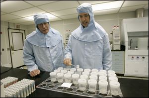 Researcher Lonnie Thompson, left, and Matt Makou, a post-doctoral investigator, analyze ice cores in the clean room at the Byrd Polar Research Center.