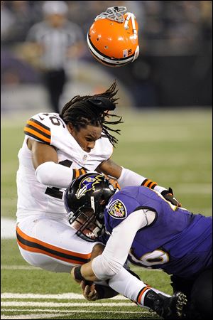 Ravens long snapper Morgan Cox tackles Browns wide receiver Josh Cribbs as his helmet is dislodged from a hit by another player during the first half tonight in Baltimore.