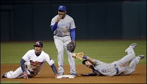 Kansas City Royals shortstop Tony Abreu (34) and second baseman Johnny Giavotella (9) plead for an out after Cleveland Indians' Ezequiel Carrera dived back into second on a line out  Friday in Cleveland. Carrera was ruled safe.