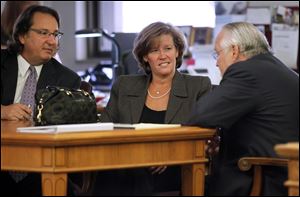 Cathleen Dooley confers with attorneys Mark Jacobs, left, and Rick Kerger, before jury selection gets under way Thursday in Lucas County Common Pleas Court.
