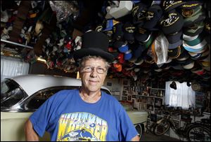 Lee McBride with his collection of 4,500 hats in his garage.