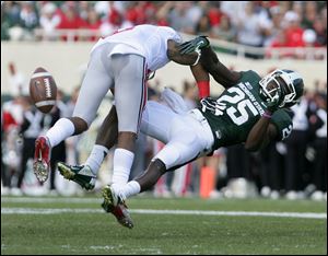 Michigan State's Keith Mumphrey is knocked off his feet by Ohio State's Rod Smith after missing a pass during the second quarter.