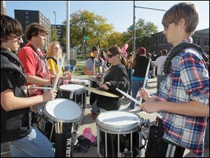 Clockwise, from left: Matt Phillips, a sophomore, seniors Brad Eisenmann and Liz Feltz, sophomore Nick Bartlett [fourth from left and facing camera], sophomore Christina Howard on the cymbals, and Garrett Weddington, a sophomore, of the Northview High School Marching Band, keep the beat for their bandmates and marchers at the event.