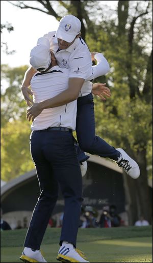 Europe's Martin Kaymer leaps into the arms of teammate Sergio Garcia after winning the Ryder Cup PGA golf tournament Sunday.