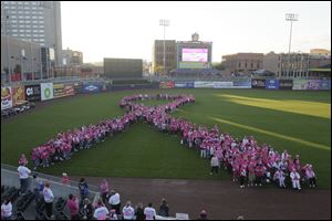 Survivors create a pink ribbon in left field in Fifth Third Field. The Komen Northwest Ohio Race for the Cure, in Toledo.