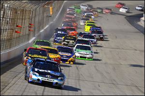 Denny Hamlin (11) leads the start during the NASCAR Sprint Cup Series auto race at Dover International Speedway, Sunday, Sept. 30, 2012, in Dover, Del.