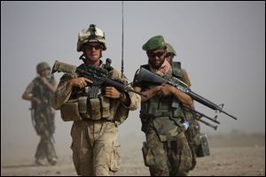U.S. Marine squad leader Sgt. Matthew Duquette, left, of Warrenville, Ill., with Bravo Company, 1st Battalion 5th Marines walks with Afghan National Army Lt. Hussein, during in a joint patrol in Nawa district, Helmand province, southern Afghanistan.