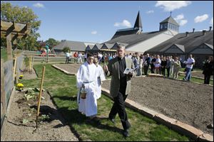 Father Kent Kaufman blesses their new garden which will provide fresh produce for outreach ministries and educational purposes in earth literacy and stewardship at the All Saints Catholic Parish and School in Rossford.