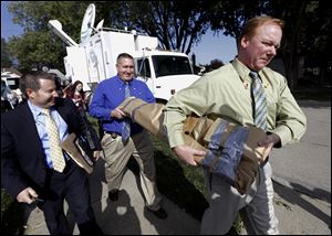 Roseville Police Department detectives carry soil samples removed from a shed floor of a Roseville, Mich., home. Police have been told by a source that former Teamsters boss Jimmy Hoffa may be buried beneath a driveway.
