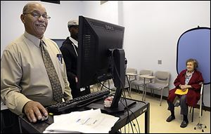Joseph Strickland prepares voter identification for Sophie Masloff, 94, of Squirrel Hill, Pa., the former mayor of Pittsburgh. The state's debate over voting rights is on hold with a judge’s decision just weeks before the presidential election.