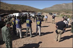 Law enforcement officers gather at a command post in the desert near Naco, Ariz., Tuesday, after a Border Patrol agent was shot to death near the U.S.-Mexico line. 