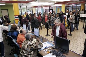 Voters wait in line to be checked in at the early vote center Tuesday at Summit Plaza in Toledo.