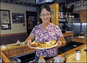 Millie Brown, a cook and waitress at Buch's truck stop, serves a breakfast, in Steubenville, Ohio.