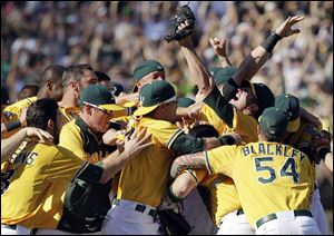 Oakland Athletics relief pitcher Grant Balfour celebrates with teammates after their 12-5 win over the Texas Rangers on Wednesday in Oakland, Calif.