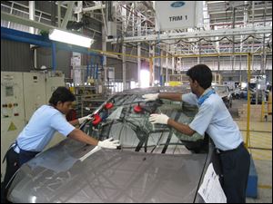 Employees work on a car at the Ford India plant in Chennai, India. Ford has invested $875 million in India since its 1995 arrival.