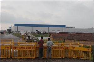 Security stands guard outside the Tata Nano production plant in Singur, India. Violent protests caused Tata Motors to abandon its nearly completed plant in Singur, depriving the rural farming communities of West Bengal of thousands of new jobs.