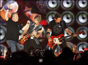 Rascal Flatts members left to right Gary LeVox,  JoeDon Rooney, and Jay DeMarcus perform Thursday at the Huntington Center.