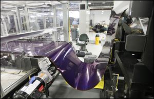 Material used in the production of solar cells goes through a machine earlier this year at Xunlight Corporation in Toledo.