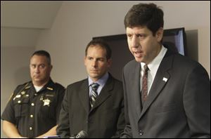 From left, Ottawa County Sheriff Steve Levorchick, and Kevin Graber from the DEA, listen as U.S. attorney Steven M. Dettlebach discusses the indictments.