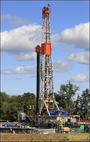 A drill rig in Carrollton, Ohio, does its work in rural Carroll County, which boasts more active oil and gas wells than any other Ohio county. the tax dollars are flowing right along.