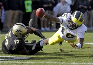 Michigan quarterback Denard Robinson, right, dives to the one-yard line as he's tackled by Purdue defensive tackle Kawann Short on Saturday in West Lafayette, Ind.